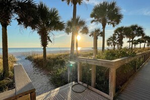 A wooden boardwalk leading to a beach with palm trees and a view of the ocean. - Beachfront Townhouse w/ Modern Upgrades Shared Pool, Fast WiFi, Outdoor Shower (Panama City Beach)