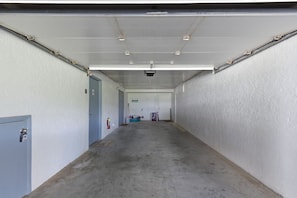 A long, narrow hallway with a concrete floor and white walls, leading to a door at the end. - Beachfront Townhouse w/ Modern Upgrades Shared Pool, Fast WiFi, Outdoor Shower (Panama City Beach)