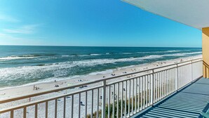 Ein Balkon mit Blick auf Strand und Meer.