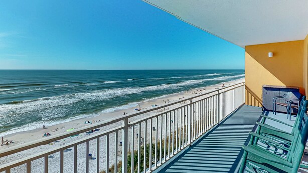 Ein Balkon mit Blick auf Strand und Meer.