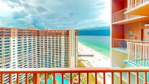 A high-rise hotel with multiple balconies overlooking a beach and a pool area. - Condo in Panama City Beach with sweeping Gulf views, pools, hot tub, & gym (Panama City Beach)