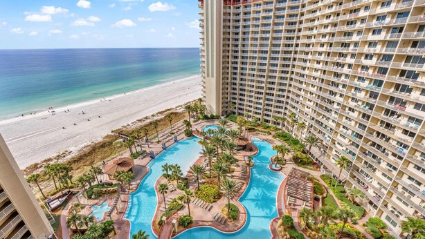 A hotel with a pool area, beach view, and multiple floors. - Condo in Panama City Beach with sweeping Gulf views, pools, hot tub, & gym (Panama City Beach)