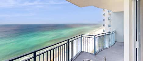 A balcony with a view of the ocean and beach.