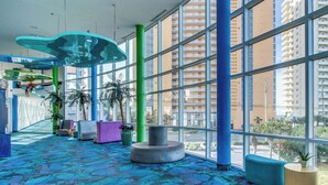 A spacious lobby with large windows, a patterned carpet, and modern seating areas. - Beachfront, high-end condo with Pool, Hot tub & Splash pad (Panama City Beach)