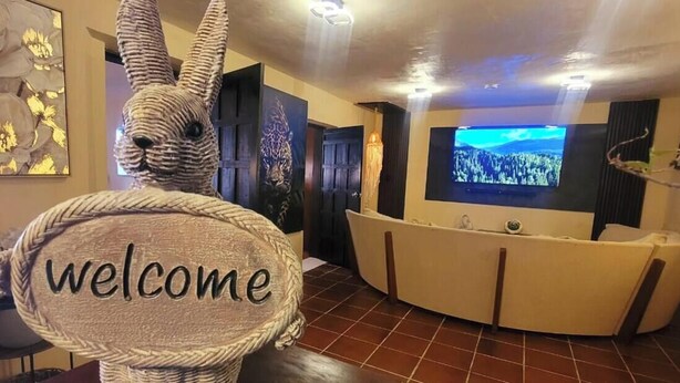 A reception area with a 'welcome' sign, a television, and a reception desk. - Casa Vacaional (Bacalar)