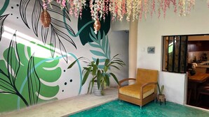 A room with a pool, a chair, and a wall with a leaf pattern. - Casa Vacaional (Bacalar)