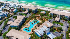 Luchtbeeld van een resort met een zwembad, strand en meerdere gebouwen.
