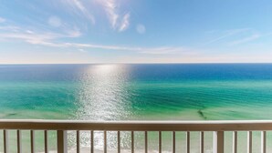 Een helder uitzicht op de oceaan vanaf een balkon met een hekwerk.