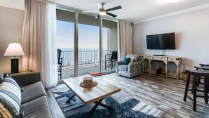 Una sala de estar moderna con un sofá, una mesa de centro, un televisor y un balcón con vistas.