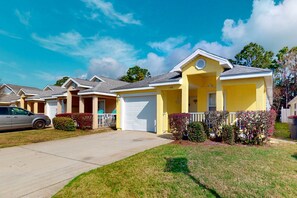 A row of yellow single-family homes with a garage, a driveway, and a lawn. - Wonderful vacation retreat close to the beach w/WiFi, central AC, & shared pool (Panama City Beach)