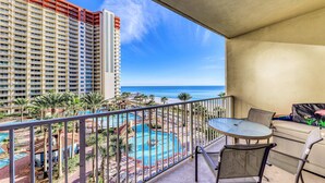 Un balcone con vista su una piscina e un alto edificio di un albergo.