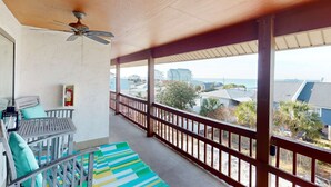 Ein Balkon mit Meerblick, ein Deckenventilator und ein Feuerlöscher.