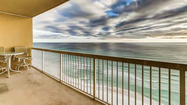Ein Balkon mit Blick auf das Meer und einen bewölkten Himmel.