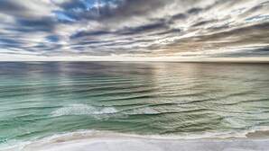 Ein Strand mit Wellen und einem bewölkten Himmel.