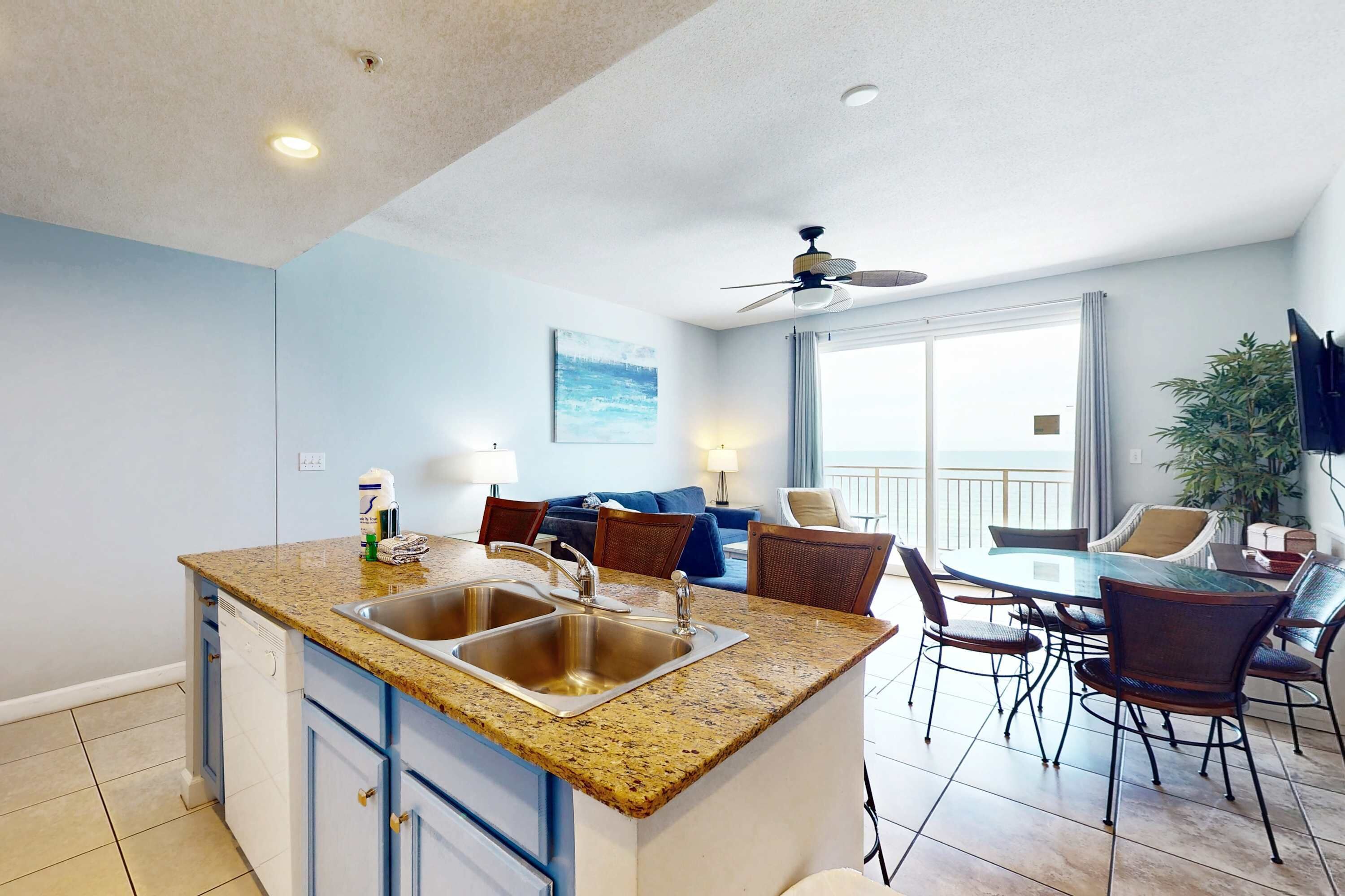 A modern kitchen with granite countertops, stainless steel appliances, and a dining area with a round table and chairs.