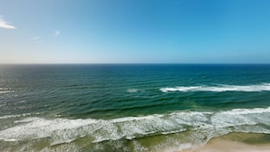 Ein Strand mit Wellen und blauem Himmel.