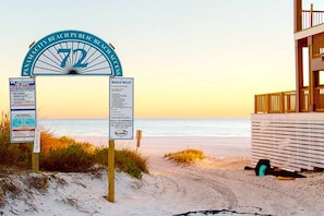 Placa de entrada para a praia com regras e aviso sobre salva-vidas.