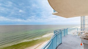 A balcony with a view of the ocean and a building in the background. - Wonderfully decorated Gulf-view condo | Pool | Hot tub (Panama City Beach)