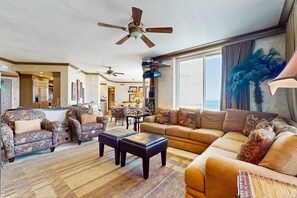 A spacious living room with a large sofa, two armchairs, a coffee table, and a ceiling fan. - Gorgeous beachfront condo, shared pool and beach access (Perdido Key)