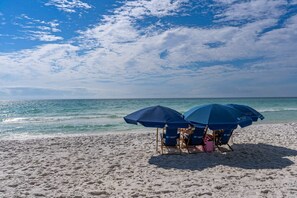 A beach with two blue umbrellas and beach chairs. - Super-comfy Seagrove condo with spacious pool-view balcony & pickleball (Santa Rosa Beach)