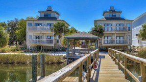 A wooden pier leading to a building with balconies and a gazebo. - Gorgeous coastal townhome with private balcony/porch, W/D, and shared pool (Pensacola)