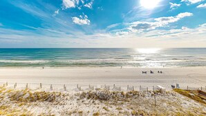 A beach with a sandy shore, a clear sky, and the ocean in the background. - Beachfront condo with Gulf views, pool, tennis courts, & balcony (Fort Walton Beach)