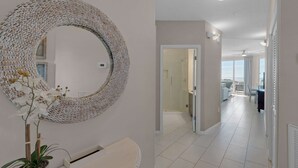 Een moderne badkamer met een grote ronde spiegel, een potorkidee en een witte wasbak.