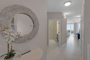 A modern bathroom with a large circular mirror, a potted orchid, and a white sink. - Bright Gulf-view condo with balcony, pool, seasonal beach service & pickleball (Santa Rosa Beach)