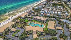 Luftaufnahme eines Hotels an der Küste mit Schwimmbad, Zugang zum Strand und mehreren Gebäuden.
