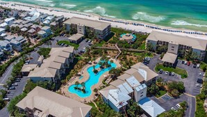 Vista aérea de un resort con varias edificaciones, una piscina y una playa.