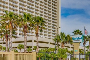 A high-rise building with balconies, palm trees, and a sign for 'Funbird Condominiums'. - Gulf-front condo with amazing views, WiFi, central AC, pools, & fitness room (Panama City Beach)