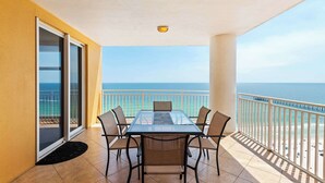 A balcony with a glass table and chairs, a view of the ocean, and a railing. - Beachfront resort condo with Gulf views, outdoor pool, & private balcony (Panama City Beach)