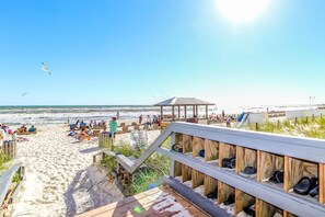 A beach with a wooden walkway leading to beach chairs and umbrellas. - Luxurious beachfront condo with ocean views, Pool & Hot tub (Panama City Beach)