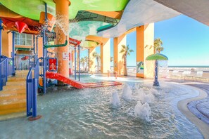 An indoor water park with slides, water features, and a view of the ocean. - Beachfront condo with amazing views, balcony, pools, waterpark, hot tub (Panama City Beach)