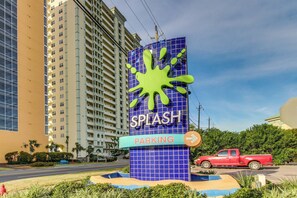 A building with a sign that reads "SPLASH PARKING" and a red truck parked in front. - Ocean and breachfront condo with pool, gym, hot tub - walk to the beach (Panama City Beach)