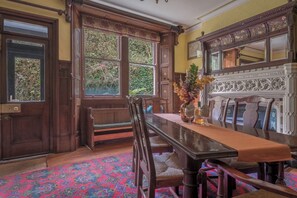 A dining area with a wooden table, benches, and a patterned carpet.