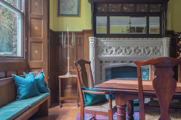 A traditional room with a wooden bench, a dining table, and a fireplace.