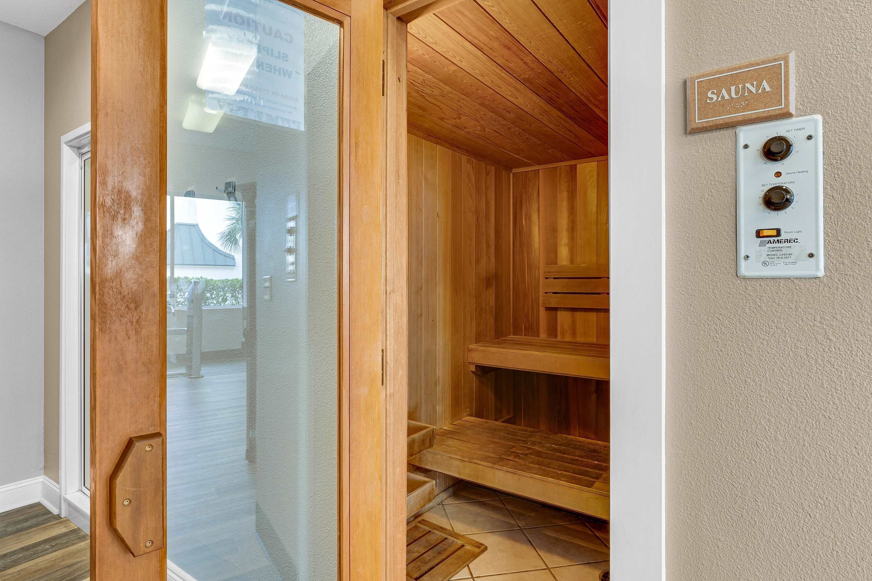 Ein Saunaraum mit Holzbänken und einer Glastür zu einem Außenbereich.
