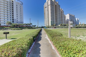 Un sendero bordeado por setos cuidados y una hilera de edificios residenciales altos.