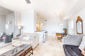 Ein modernes Wohnzimmer mit einer Couch, einem Couchtisch und einem Essbereich mit Tisch und Stühlen.