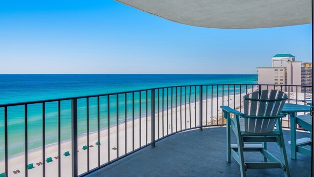 Un balcon avec vue sur une plage et l’océan.