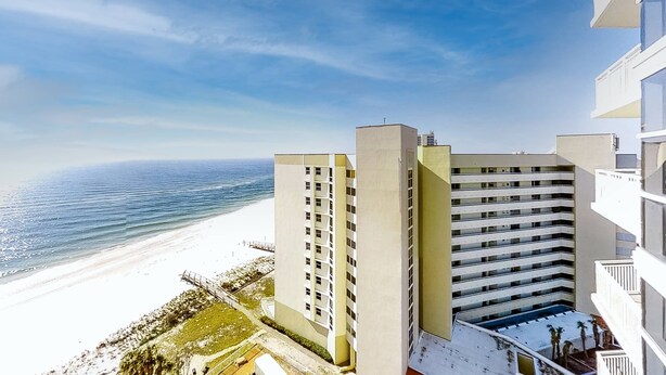 A high-rise hotel overlooking a beach with a clear view of the ocean. - Coastal condo steps to beach with pools, hot tub, gym & amazing views (Perdido Key)