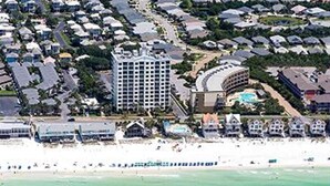 Vista aerea di una zona costiera con un hotel, spiaggia e oceano.