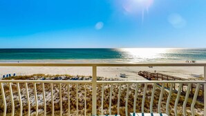 A beach view from a balcony with a railing, sandy beach, and ocean. - Gulf-front condo with complimentary beach equipment - near shops & dining (Destin)