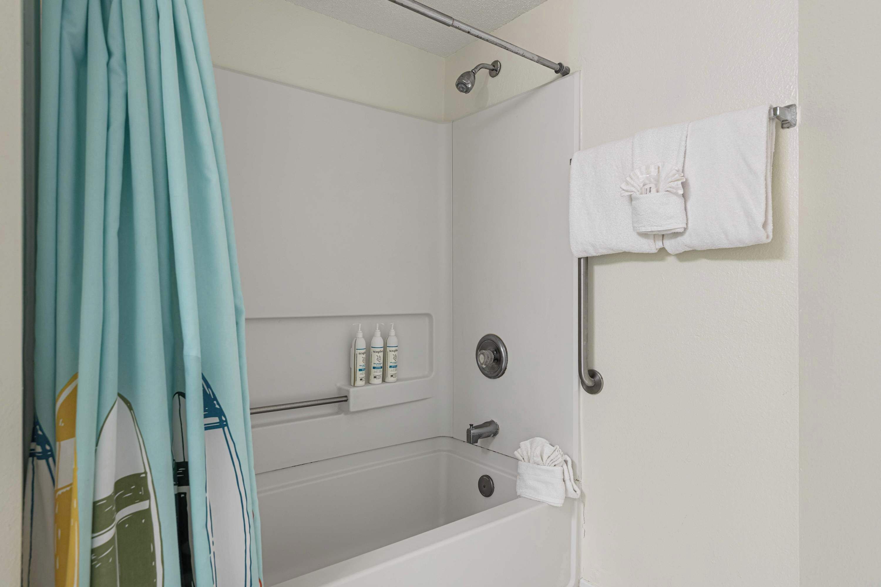 A bathroom with a bathtub, shower, and a towel rack.