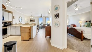 Eine geräumige Küche mit Kochinsel, ein Essbereich mit Blick und ein Schlafzimmer mit Bett und Deckenventilator.