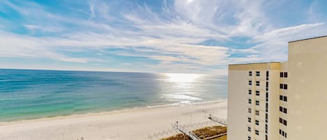 A beach view from a high-rise building with a clear sky and ocean.