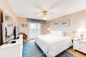 A hotel room with a large bed, a desk with a computer, a chair, a balcony, and artwork on the walls. - Fourth floor oceanfront condo with pool access, washer&dryer, and central AC (Fort Walton Beach)