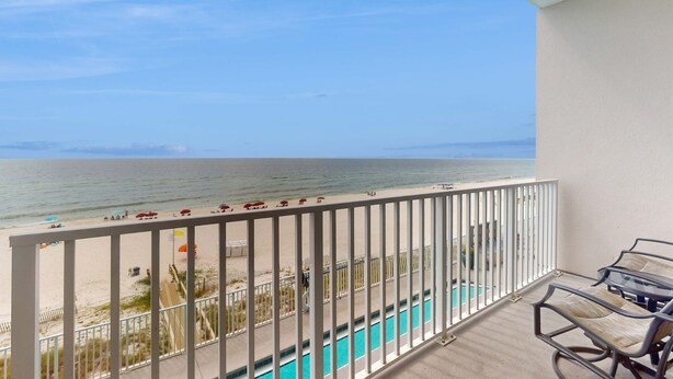 En balkon med udsigt over stranden og havet.