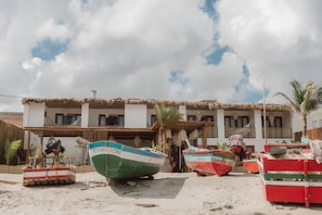 A coastal building with thatched roofs, surrounded by boats. - Ankura Preá Spa & Boutique Hotel (Cruz)